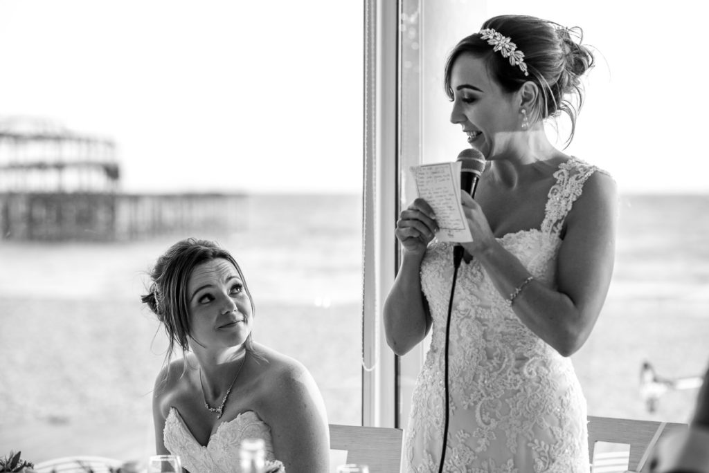 Bride smiling at bride during speeches