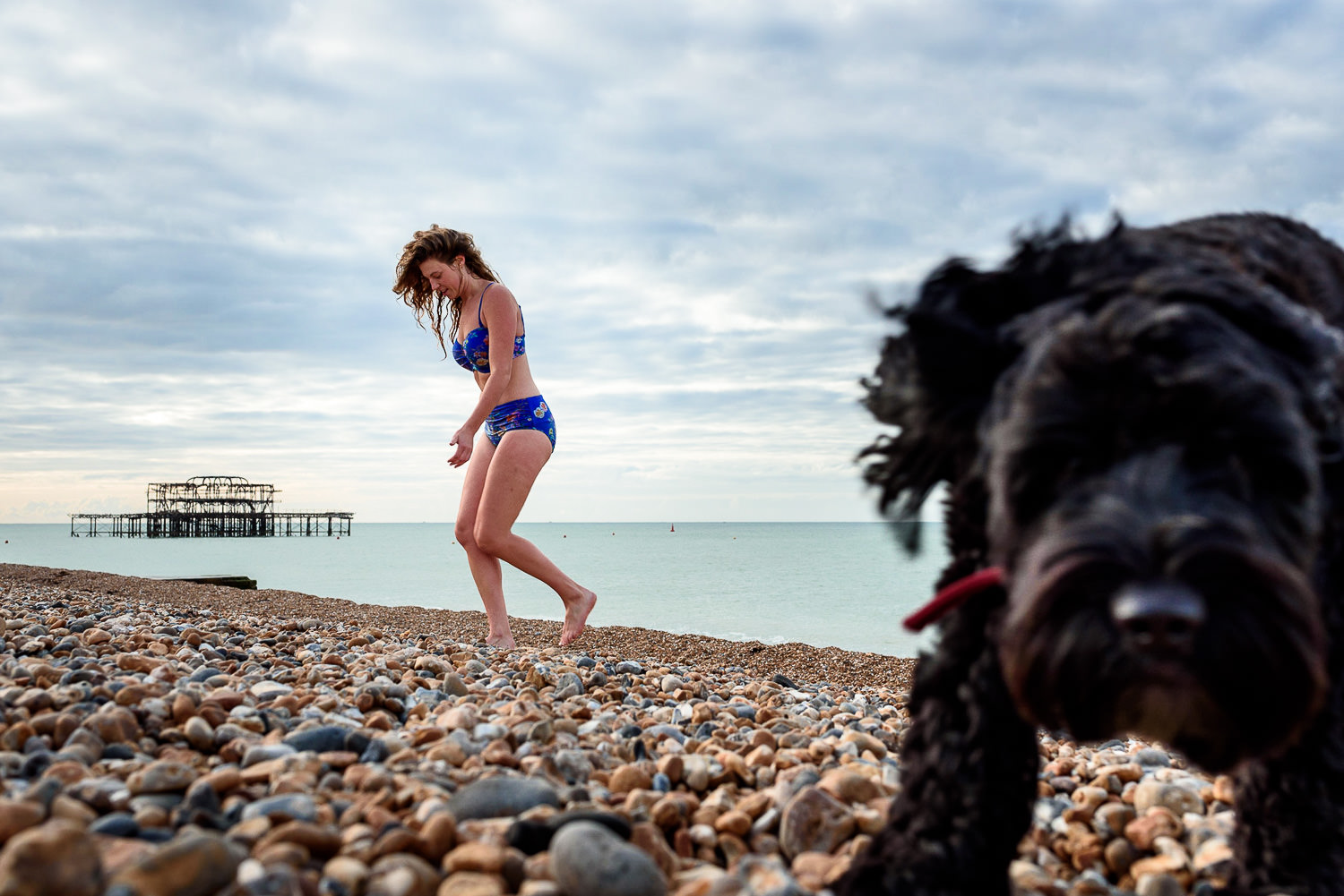 Bride walking on Brighton Beach after a swim in the sea