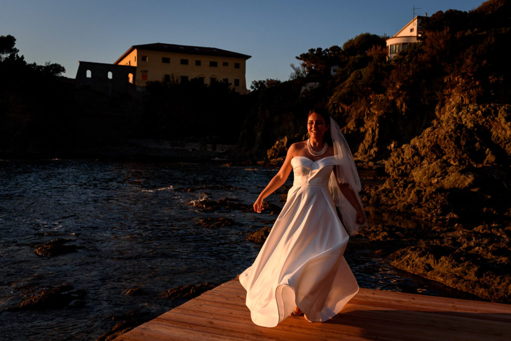bride playing with her dress on a beach in Castiglioncello